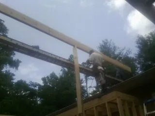 Carpenter setting a ridge beam over a new addition frame — Ice Dam Removal by Roofing Brothers in Baldwin Park